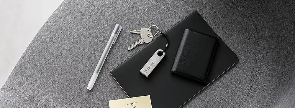 Ledger Nano S Plus am Schlüsselbund auf einem Notizbuch